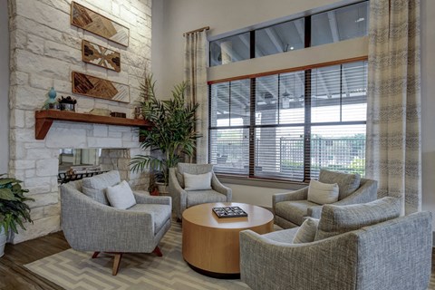 a living room with couches and chairs and a stone fireplace